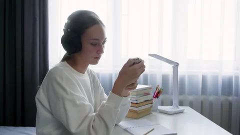 Young student playing mobile game while wearing headphones Stock Footage 315174240
