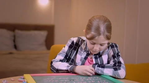 Young student practicing writing on small chalkboard Stock Footage 315876454