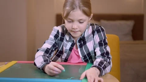 Young student practicing writing on small chalkboard Vidéo 315876477