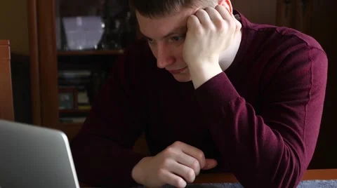 Young student reading notes on his laptop. He is focused. Stock Footage 61281155
