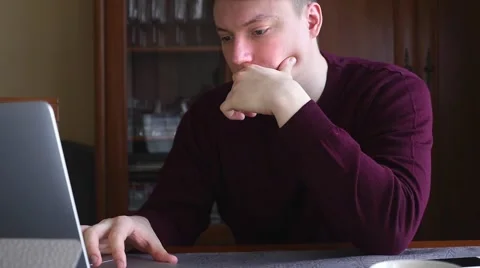 Young student reading notes on his laptop. He is focused. Stock Footage 61281701