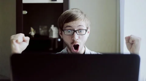 Young student rejoices sitting in front of laptop Video stock 63319306