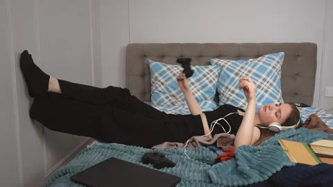 Young student relaxing on bed listening to music 库存影片 309777918