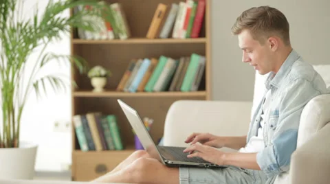 Young student relaxing on sofa and using laptop Stock Footage 27691898
