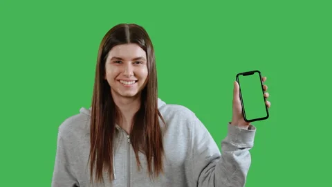 Young student showing to the viewers mobile with green screen Stock Footage 207466473
