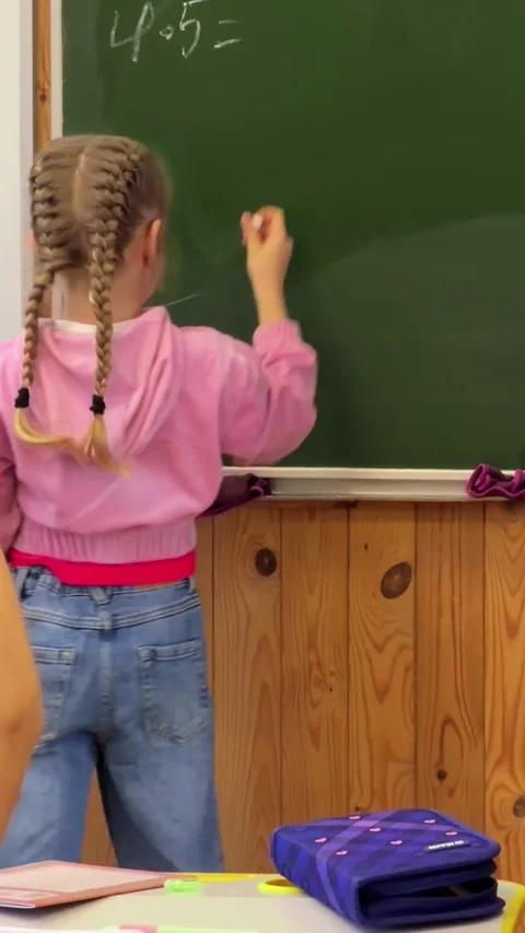 A young student solving math problems on a classroom chalkboard, conveying .. Stock Footage 339861345