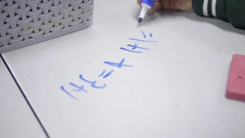 Young Student Solving Simple Math Problems On School Table With Marker Stock Footage 312848186