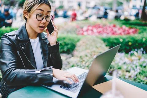 Young student in spectacles e learning on netbook while making roaming talking Stock Photos