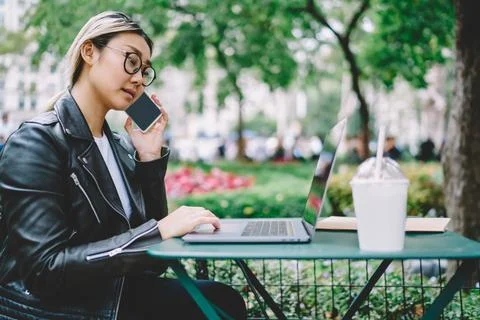 Young student in spectacles e learning on netbook while making roaming talking Stock Photos