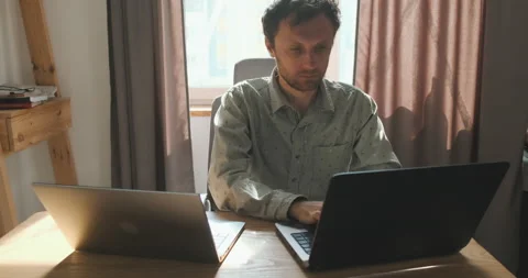 Young student studies on two laptops at the same time. Portrait, desktop at home Stock-Footage 204134195