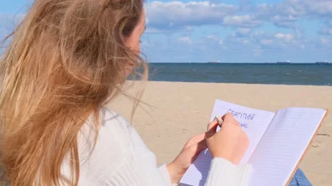 Young student study with notebook on beach next to sea ocean view. Writing Stock Footage 219596718