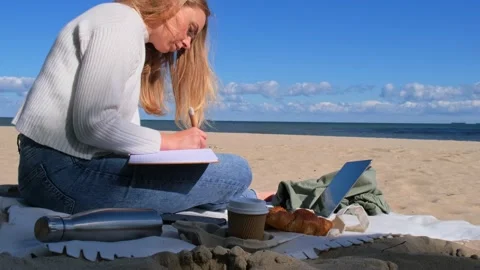 Young student study with notebook on beach next to sea ocean view. Writing Stock Footage 219596754