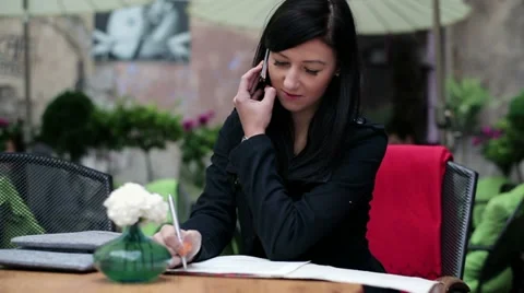 Young student talking on cellphone and writing notes in cafe HD Stock Footage 11136416