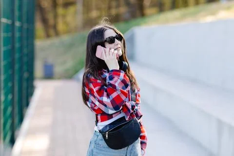 Young student talking on smartphone walking outdoor in the city Stock Photos