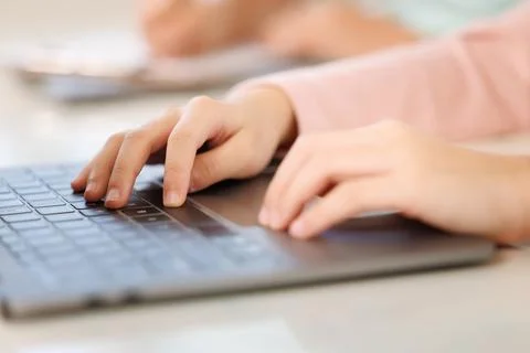 Young Student Typing On Laptop Computer In Bright Classroom Environment Clo.. 库存照片