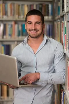 Young student using his laptop in a library Stock-Fotos