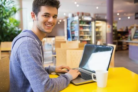 Young student using his laptop in cafe 스톡 사진