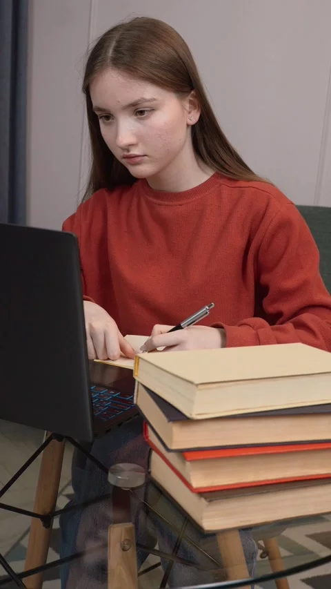 Young student using smartphone while studying at home Stock Footage 311780749