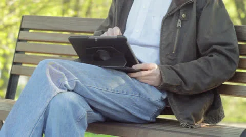 Young Student Using Tab in City Park Stock Footage 24066762