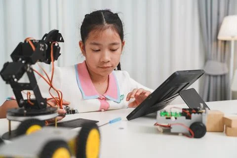A young student using a tablet for her interactive robotics lesson. Stock Photos