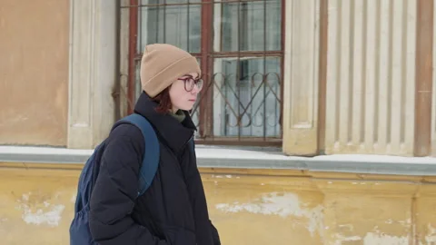 Young student walking near university building in winter Stockbeeldmateriaal 311333053