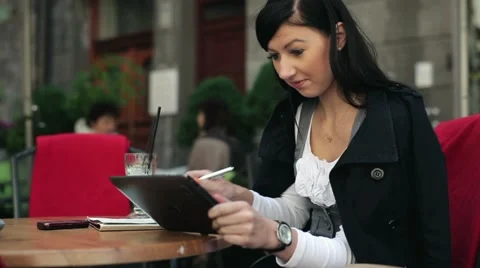 Young student working on tablet and writing notes in cafe HD Stock Footage 11137542