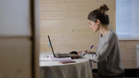 Young student write in notebook and work on laptop Stock Footage 129008859