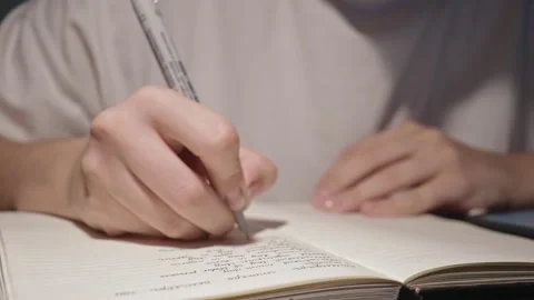 Young student write slowly in notebook doing homework, thoughts in daily journal Stock Footage 163251708