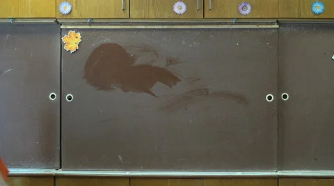 A young student writes with chalk on a blackboard Stock Footage 62652263