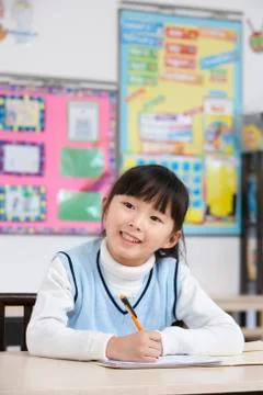 Young student writing in classroom Stock Photos