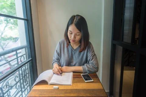 Young student writing note, take note, doing homework on book Stock Photos