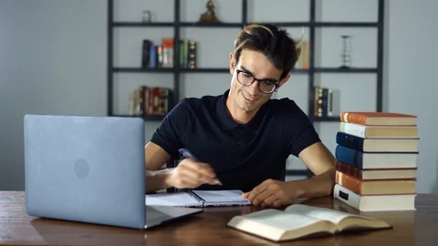 Young Student writing notes as studying distant learning courses at home Stock Footage 93299981