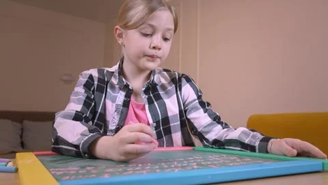 Young student writing on small chalkboard at home Vidéo 315876427