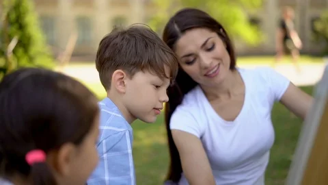 Young students answer on teachers test while she writes it on whiteboard. Stock Footage 126292989