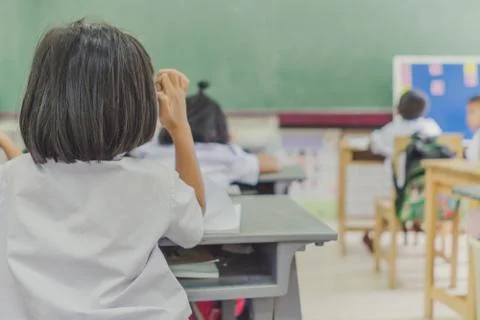 Young students are studying in the elementary school classroom. Stock Photos