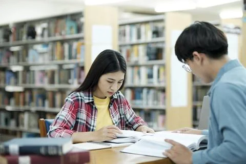 Young students campus helps friend catching up and learning. Stock Photos