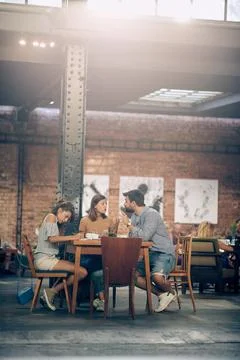 Young students on a coffee break, discussing something and writing. Stock Photos