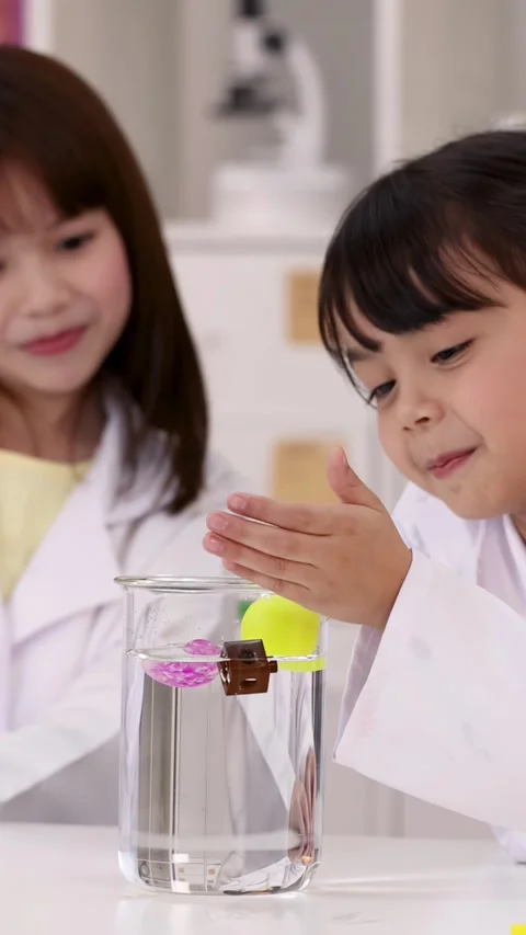 Young Students Conducting Buoyancy Experiment with Beaker in Science Lab Stock-Footage 345318614