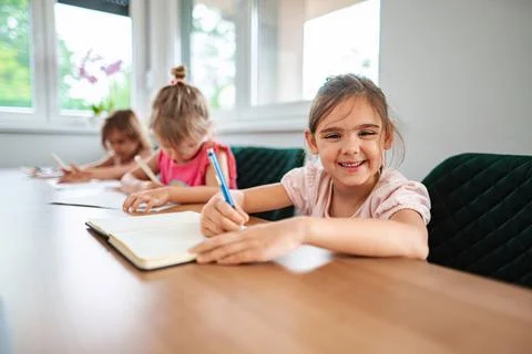 Young students engaging in creative learning at a table Stock Photos