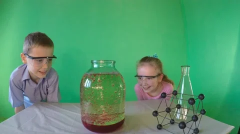 Young students in goggles watching violent chemical reaction. 库存影片 60606170