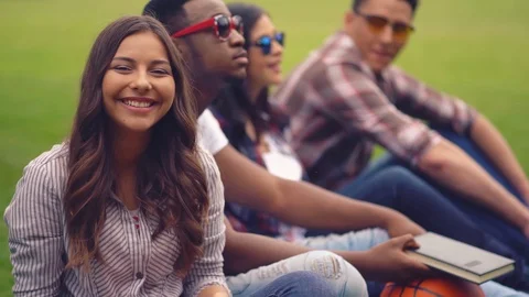 Young students have fun in between classes on the lawn near the university Stock Footage 126282170