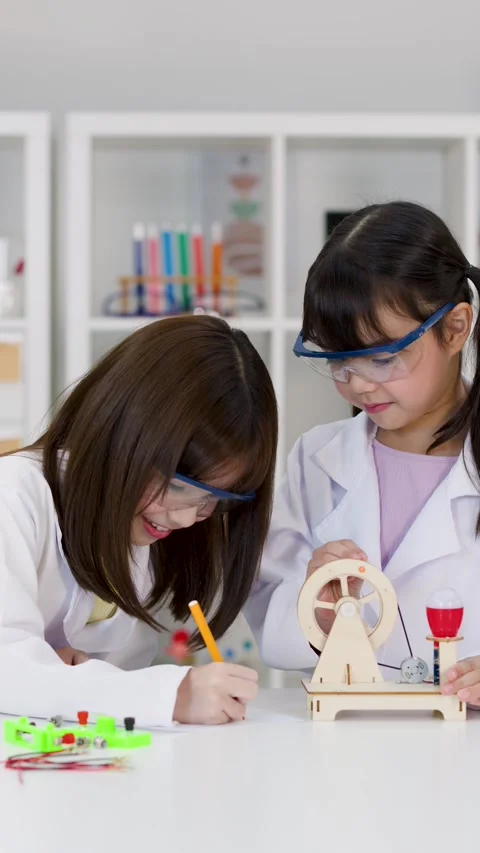 Young Students in Lab Coats Conducting Science Experiment in Classroom Stock Footage 340118093