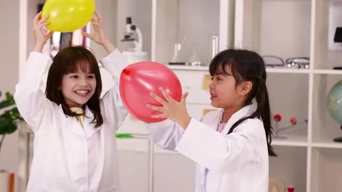 Young Students in Lab Coats Performing Static Electricity Balloon Experiment Stock-Footage 342714307