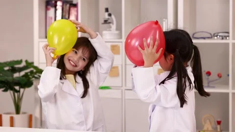 Young Students in Lab Coats Performing Static Electricity Balloon Experiment Stock-Footage 342714322