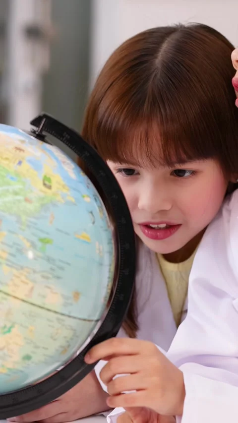 Young Students in Lab Coats Studying World Globe in Classroom Stock Footage 345318476