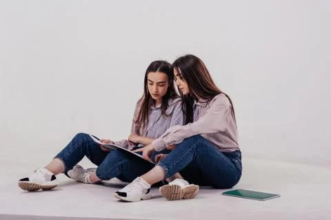 Young students learn new stuff. Two sisters twins sitting and posing in the s Stock Photos