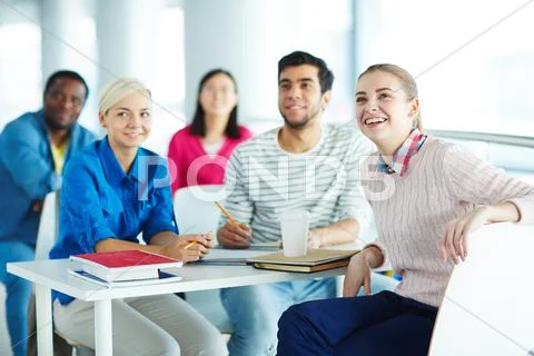 Young students listening to teacher at lesson Stock Photos