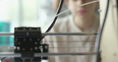Young students looking at the 3D printer printing a prototype Stock Footage 168336460