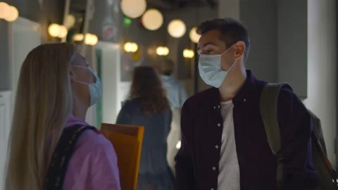 Young students in protective mask talking standing in university corridor during 스톡 동영상 139043154
