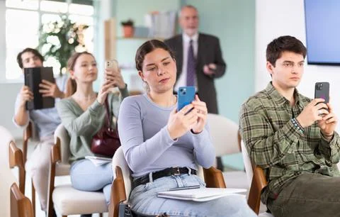 Young students scanning QR-code with mobile devices during presentation Stock Photos